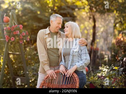 Happy senior retired couple embracing, resting in countryside and looking at each other with love Stock Photo