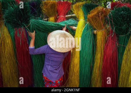 Back side of Vietnamese female craftsman drying traditional vietnam mats in the old traditional village at dinh yen, dong thap, vietnam, tradition art Stock Photo