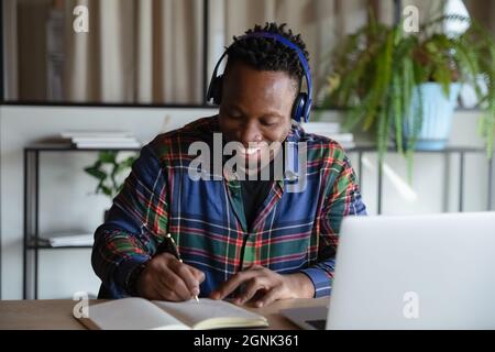 Happy student guy in wireless earphones taking distance learning course Stock Photo