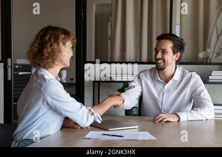Happy employer hiring candidate after interview, congratulating on getting job Stock Photo