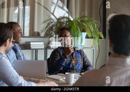 Happy African American hipster worker speaking on meeting, discussing project Stock Photo