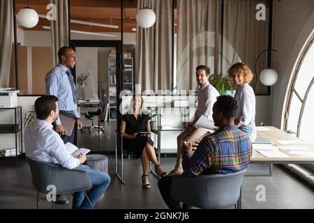 Diverse business team sitting on chairs in circle Stock Photo