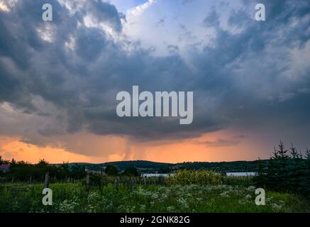 Impressive thunderstorm during a colorful sunset over the landscape in eastern Europe Stock Photo