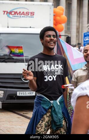 young LGBT black man wearing T shirt with slogan Black Queer Joy at Birmingham Pride Saturday 25th September 2021 Stock Photo
