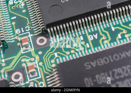 Gull-wing legs or pinouts of an integrated circuit / IC semiconductor & green pcb circuit board. For electronics technology, world micro chip shortage Stock Photo