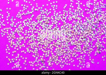 Background of shiny little stars on a bright pink background. Christmas concept. Glitter texture. Stock Photo