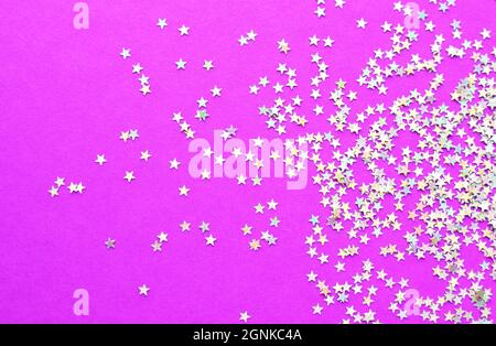 Background of shiny little stars on a bright pink background. Christmas concept. Glitter texture. Stock Photo