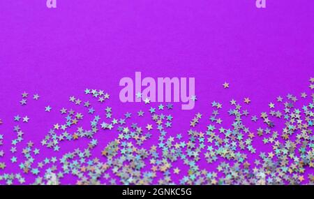 Background of shiny little stars on a bright  background. Selective focus. Christmas concept. Glitter texture. Stock Photo