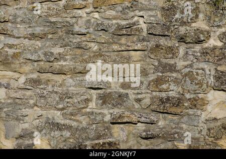Background stone wall lined with natural stone, The stone wall is lined with natural stone and cemented. Natural building material. Medieval backgroun Stock Photo
