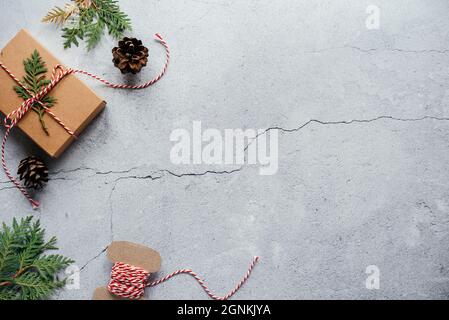 Christmas gift box, pine cones, and thuja branches on gray cement background with copy space Stock Photo