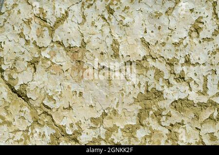 Clay wall. Wall background with shabby paint and crack, old hut wall. Cracks in the wall of a hut. Abstract background. Material construction. Detail Stock Photo
