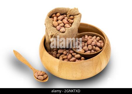 Peanuts in sack and in small wooden cup in wooden bowl on white background with clipping path Stock Photo