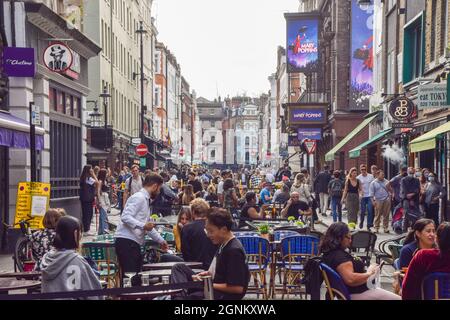 Busy bars, cafes and restaurants in Old Compton Street, Soho, as temporary al fresco street seating, introduced as a result of the coronavirus pandemic, continues in Central London. London, United Kingdom. 26th September 2021. Stock Photo