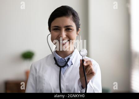 Happy smiling young Indian doctor head shot portrait Stock Photo