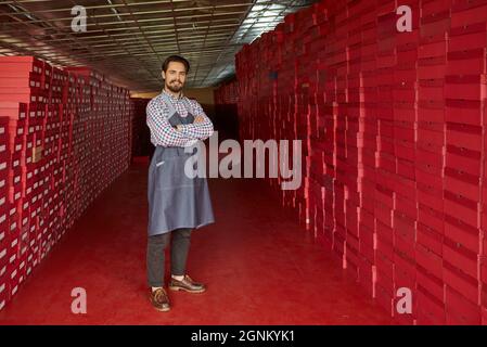 Portrait of happy shoe business owner, manager or factory worker standing in warehouse Stock Photo