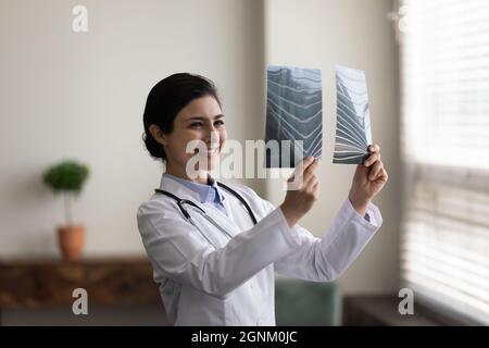 Happy young Indian doctor looking at xray radiography images Stock Photo