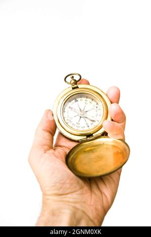 hand holding an antique brass compass for direction Stock Photo
