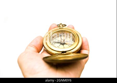 hand holding an antique brass compass for direction Stock Photo