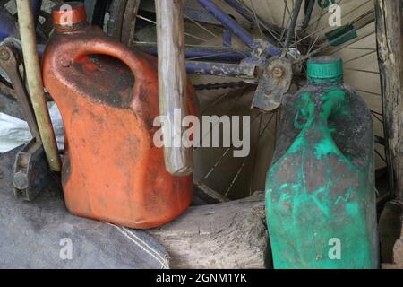 Old Gasoline cans placed on workshop outdoors, Dirty looking fuel containers that stores oil Stock Photo