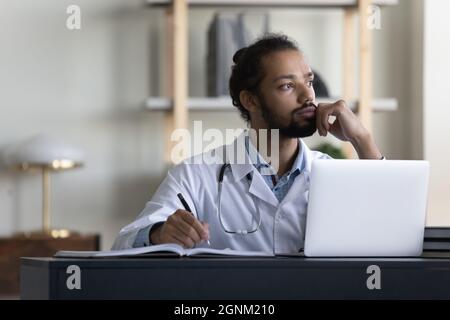 Thoughtful serious male doctor looking at window in office Stock Photo