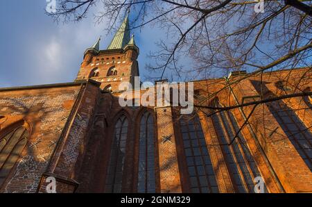 A low angle shot of the St. Peter's Church under the sunlight and a cloudy sky in Lubeck, Germany Stock Photo
