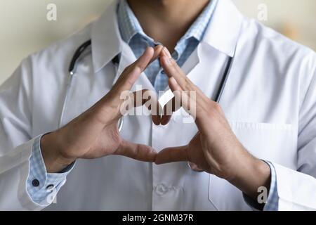Young male GP doctor making hand and finger heart shape Stock Photo
