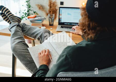 Young beard college student sit by the work table and prepare to pass exam to university. University student studying and making notes at campus. Stock Photo