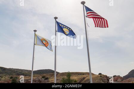 Crow Nation, Montana and United States Flags fly at the Yellowtail Dam recreation park in the Big Horn river canyon Stock Photo