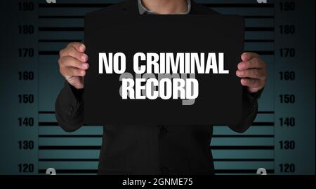 No criminal record background with young man holding signboard in a jail or prison for investigation. Stock Photo