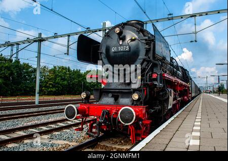 A view of the German 40's steam train arriving at the train station.A black Berlin coal distiller of 192 tons, built in 1940, and taken off the German rails, once bought by a private individual and donated to the Stoom Stichting Nederland organization, because of its museum value arrived today at the Central train station in Nijmegen, where hundreds of people were waiting to see it. Since 2018, the steam locomotives have been driving back and forth between Nijmegen and Den Bosch for one day every year, to bring the past back to life. Stock Photo