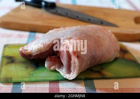 Raw turkey thigh on glass cutting board Stock Photo