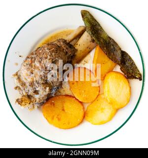 Braised pork knuckle with fried potatoes and baked pepper Stock Photo