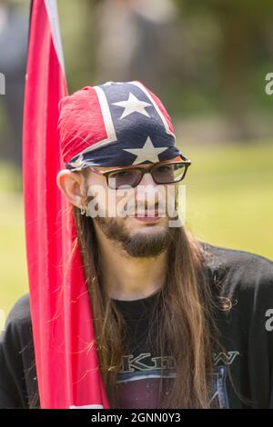 A confederate supporter gathers at the South Carolina capital building wearing a rebel flag head scarf to mark Confederate Memorial Day May 7, 2016 in Columbia, South Carolina. The events marking southern Confederate heritage come nearly a year after the removal of the confederate flag from the capitol following the murder of nine people at the historic black Mother Emanuel AME Church. Stock Photo