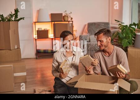 Portrait of happy adult couple unpacking boxes while moving in to new home, copy space Stock Photo