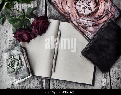 Still life with old decorated book with shabby pages, roses on wooden planks background. Knowledge concept with empty vintage diary and copy space, to Stock Photo
