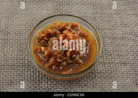 Red wine sauce with bacon and chopped shallot on glass ingredient bowl on gray burlap Stock Photo