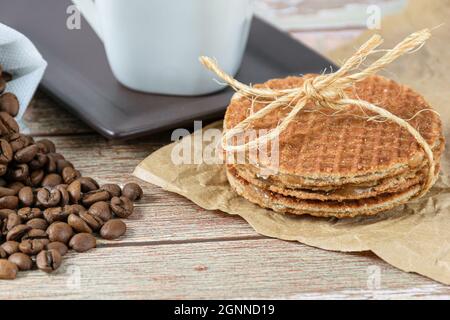 closeup of stroopwafel biscuits with a sisal bow next to coffee beans. Stock Photo