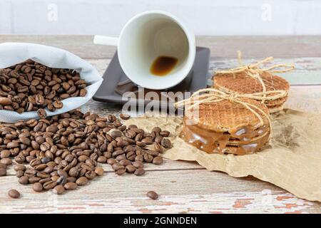 Stroopwafels stacked on brown paper, next to a lying coffee cup. Stock Photo