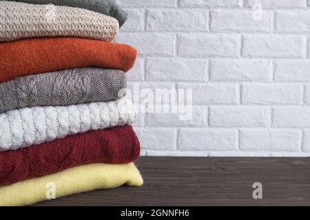 Folded knitted warm sweaters, half-overs or blankets. Autumn and winter clothes. Stock Photo