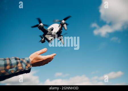 Man pilot Launches quadcopter drone from hand to sky flight Stock Photo