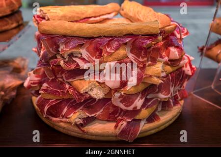 Serrano iberico ham sandwiches or bocadillo held on a wooden platter at a local shop in Pamplona Spain Stock Photo