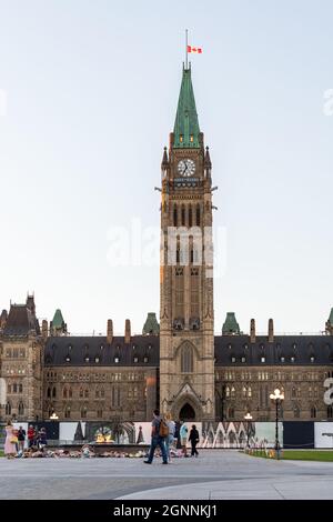 Ottawa, Canada - September 19, 2021: Parliament building with canadian flag in the capital of Canada, Ottawa against sky. Peolpe walking near centenni Stock Photo