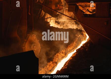 The process of tapping molten metal and slag from a blast furnace. Stock Photo