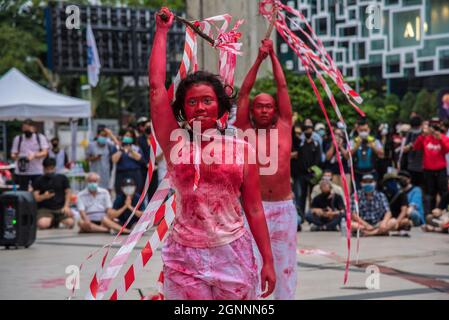 Bangkok, Thailand. 26th Sep, 2021. Protesters covered in red paint seen performing during the demonstration.Pro-democracy protesters gathered at the Bangkok Art and Culture Center (BACC) on September 26, 2021 to mark the 1st anniversary of political movement in Thailand that led by United Front of Thammasat and Demonstration (UFTD) demanding the resignation of Prayut Chan-O-Cha and the monarchy reform. Credit: SOPA Images Limited/Alamy Live News Stock Photo