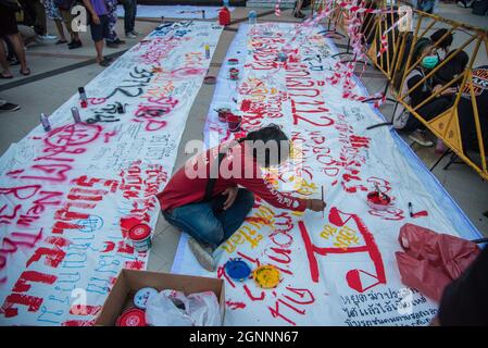 Bangkok, Thailand. 26th Sep, 2021. A protester paints a banner during the demonstration.Pro-democracy protesters gathered at the Bangkok Art and Culture Center (BACC) on September 26, 2021 to mark the 1st anniversary of political movement in Thailand that led by United Front of Thammasat and Demonstration (UFTD) demanding the resignation of Prayut Chan-O-Cha and the monarchy reform. Credit: SOPA Images Limited/Alamy Live News Stock Photo