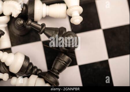 A chess board and black and white chess pieces on a wooden table, close-up, selective focus Stock Photo