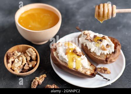 grilled pears baked with ricotta cheese and walnuts. honey topping. diet sweet dessert, vegetarian food.  Stock Photo