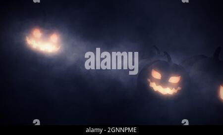 Halloween pumpkins head jack o lantern and creepy mist in scary deep night background with copyspace. Stock Photo