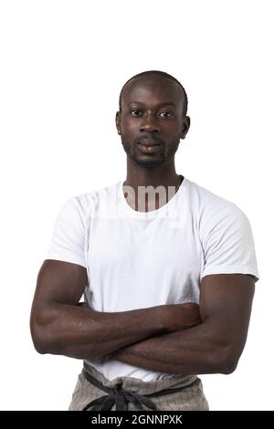 African waiter with a white T-shirt and crossed arms poses on white background. Studio portrait. Copy-space Stock Photo
