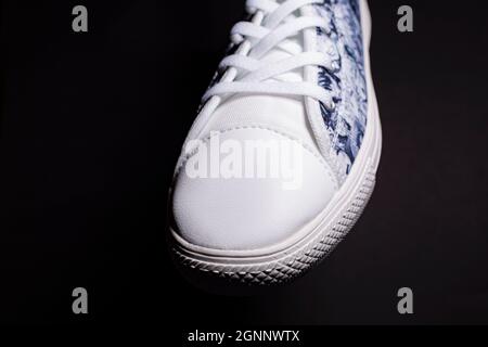 Close up of black and white shoe sneakers on black background Stock Photo